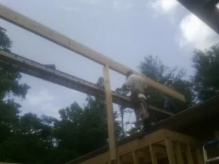 Carpenter setting a ridge beam over a new addition frame — Ice Dam Removal by Roofing Brothers in Willingboro