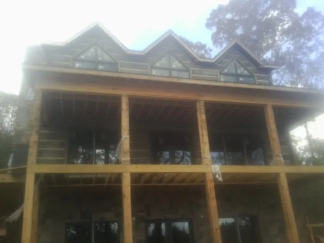 Dormers and porch framing on a large log home under construction — Roof Coating work by our crew in Willingboro