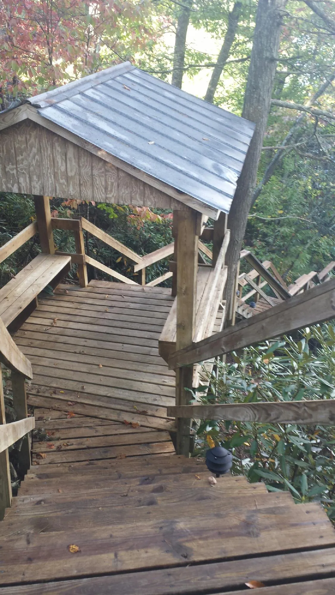 Metal roofed shelter over wooden steps on a wooded walkway — Skylight Repair & Installation work by our crew in Willingboro